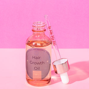 A bottle of hair growth oil by Happy Whole You.